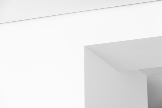 Minimal white interior showcasing a modern geometric corner and clean lines.Negative space, soft shadows and architectural simplicity create a calm, contemporary and abstract visual composition 