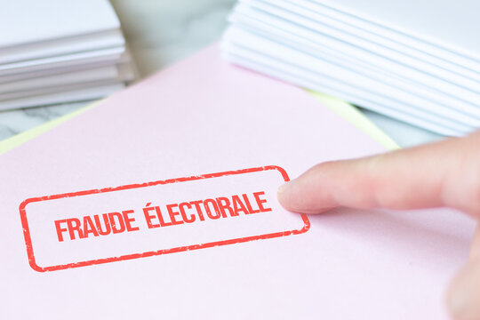 Electoral fraud stamp in French applied to a folder next to folded and sorted ballot papers, reporting of irregularities in the democratic process. Electoral offense