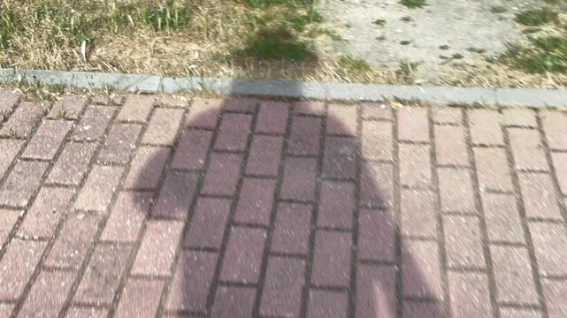 POV walking with shadow on brick pavement