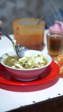 A bowl of hot soto lontong with rising steam tempting the customer while being enjoyed