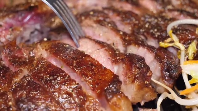 A close-up, high-definition shot of a medium-rare grilled beef steak, likely a ribeye, that has been expertly sliced on a cutting board. The rich brown crust from seasoning and the pink, juicy interio
