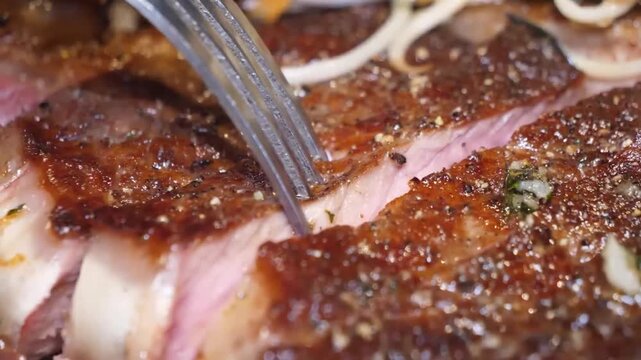 A macro shot showcasing a perfectly seared and seasoned lamb chop. The footage focuses on the rich, caramelized crust and the glistening juices as a fork gently presses into the meat, emphasizing its 