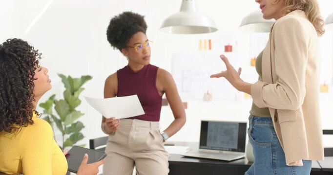 Three women team standing initiating meeting for decision, center woman reading paper in office