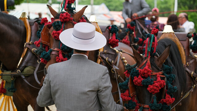 Jinete a caballo con sombrero en feria.