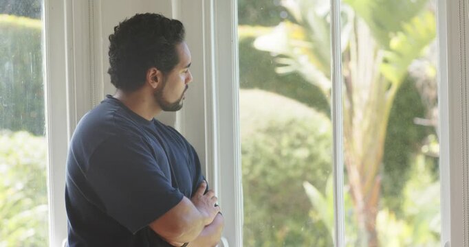 Sun nudging African American man scanning yard at window uncrossing readying to speak, copy space