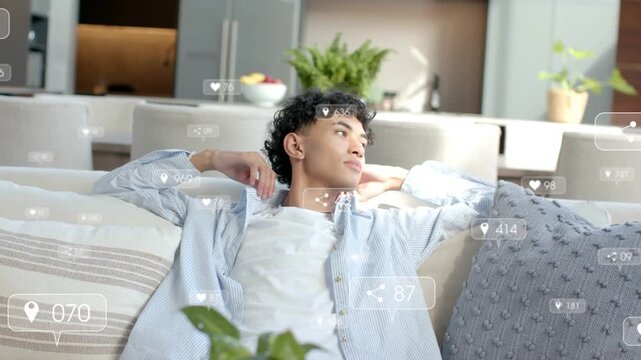 Vertical video: Lying man in blue shirt turning head, raising hand on sofa with overlays appearing