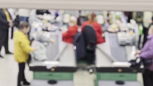 Workers help customers check out items at a busy grocery store in the afternoon