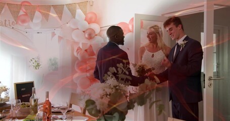 Naklejka premium Greeting newlyweds wearing wedding attire at reception doorway, with bouquet, balloons and table