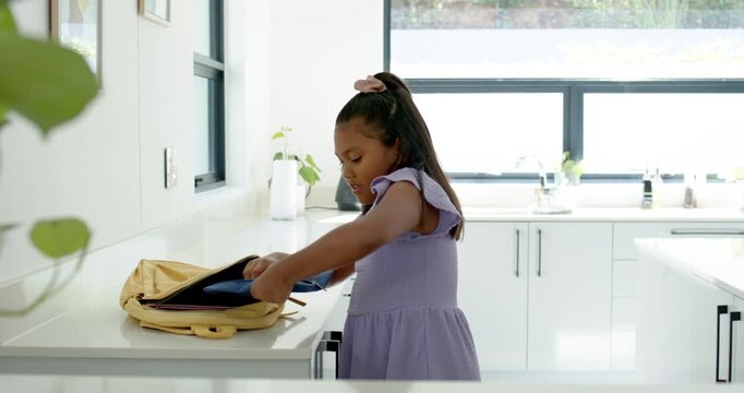 African American child in lavender dress unzipping yellow backpack sorting blue supplies for school