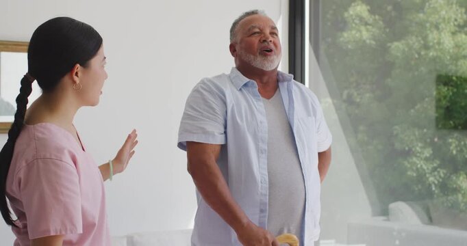 Diverse dad-daughter standing at home man voicing causing her calming touch, holding yellow object