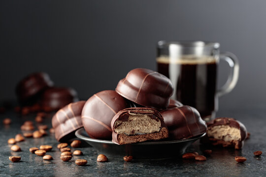 Chocolate-covered coffee souffl&eacute; cookies and cup of black coffee.