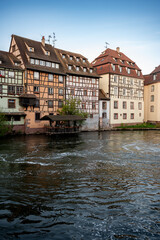 Obraz premium Row of Timber Houses Reflecting Canal at Golden Hour