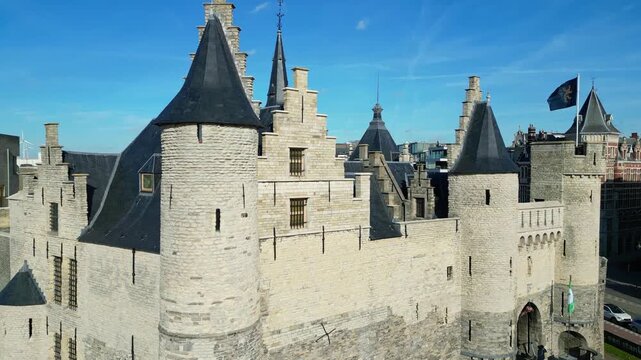 Aerial drone shot of Het Steen, a medieval fortress in the old city center of Antwerp, Belgium. View of the castle located on the banks of the Scheldt river.