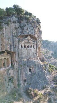 5-second vertical drone pull-back from Kaunos rock tombs, quick cinematic reveal