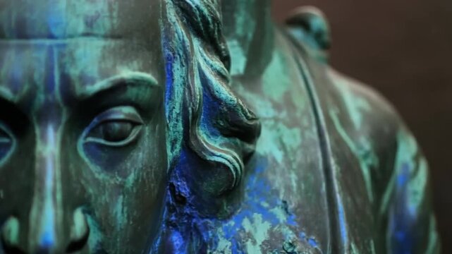 Close-up of aged bronze statue face with verdigris patina, abstract texture