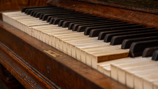 Vintage piano keyboard with aged wooden casing and time‑worn keys 