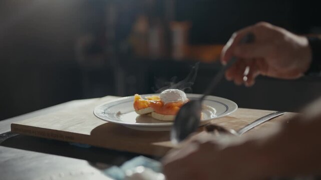 Hands place a delicate egg onto fresh toast. Warm light spills across the wooden board. Chef's focus shines through the steam and action. Perfect for food blogs or fine dining ads
