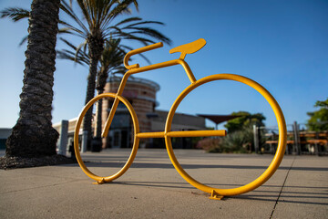 Fototapeta premium Low angle view of a yellow bicycle rack in the shape of a ten speed bike in a shopping area