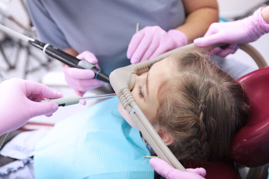 It is convenient for a little girl to treat her teeth under surface sedation. Treatment of children's teeth with nitrous oxide. Treatment of baby teeth.