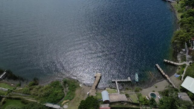 wooden dock pier at lake atitlan in guatemala (volcanic caldera crater) deepest lake in central america morning light beautiful relaxing travel destination blue turquoise water volcano view santa cruz