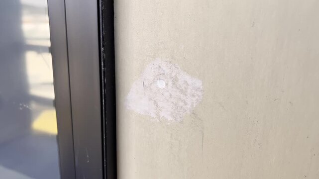 A gloved worker is plastering a wall during interior renovation.