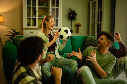 Happy friends watching football at home