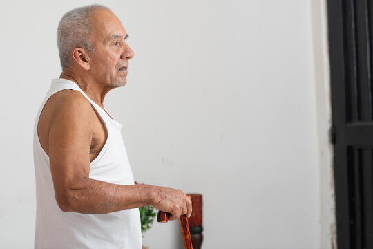 Elderly man walking with cane showing mobility limitation and independence in daily life