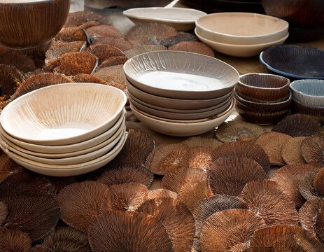 handmade ceramic plates and bowls drying before being bisque fired