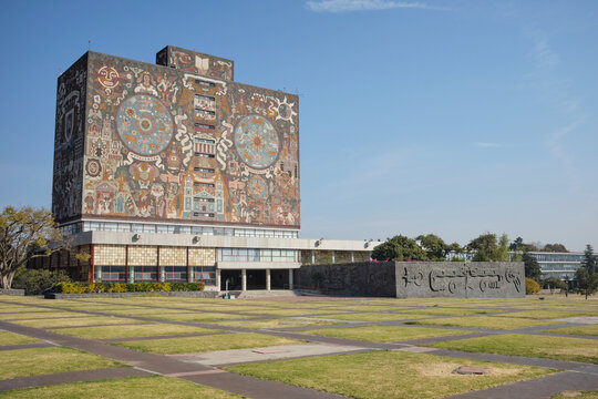 The Universidad Nacional Aut&oacute;noma de M&eacute;xico - UNAM -building in Mexico City features large-scale murals depicting cultural and historical themes under clear blue skies.