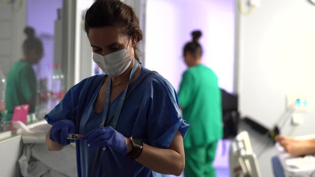 Female medical professional in a hospital setting preparing a medication dose in a syringe