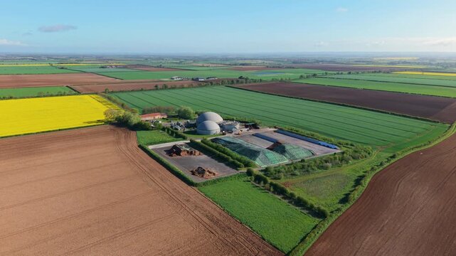 Aerial view of FBG Grange Farm Energy biogas plant with domed digesters and colorful agricultural fields in Market Rasen, England, United Kingdom.