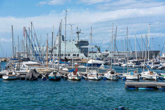 Simon's Town western cape South Africa. 08.02.2026. Numerous sailboats are docked in a vibrant marina,  A301 auxilary sship SAS Drakensberg anchored in the background on a clear day