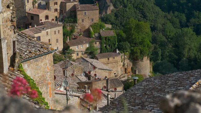 Sorano ancient tuff town slow panning shot. Gradual panning shot revealing the ancient medieval village of sorano, built into tuff rock and surrounded by lush green woods