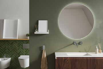 Modern bathroom interior with round mirror, floating wood vanity, olive green wall, toilet area,...