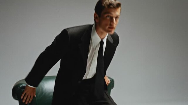 A confident professional man in a tailored suit sits elegantly, exuding an air of sophistication and style.