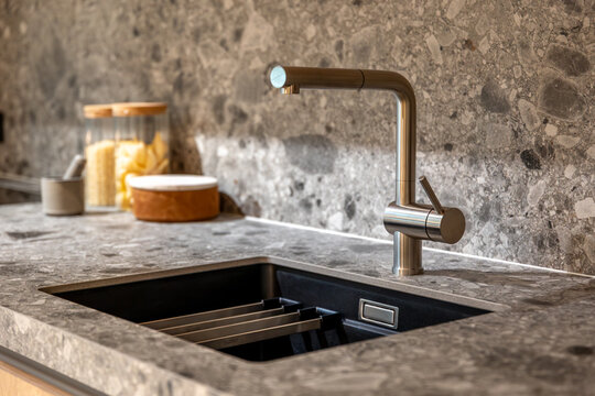 Modern kitchen faucet over a granite sink. Stylish and functional design.