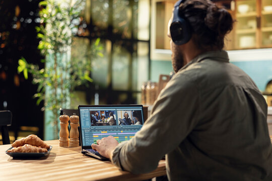 Man editing video clips and sound effects with headset at laptop, videography and post production with cinematic color grading. VFX elements and interactive software, professional content creator.
