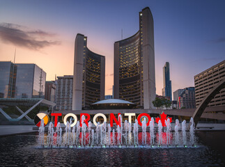 Naklejka premium Illuminated Nathan Phillips Square at sunset with Toronto Sign and Toronto City Hall - Toronto, Ontario, Canada