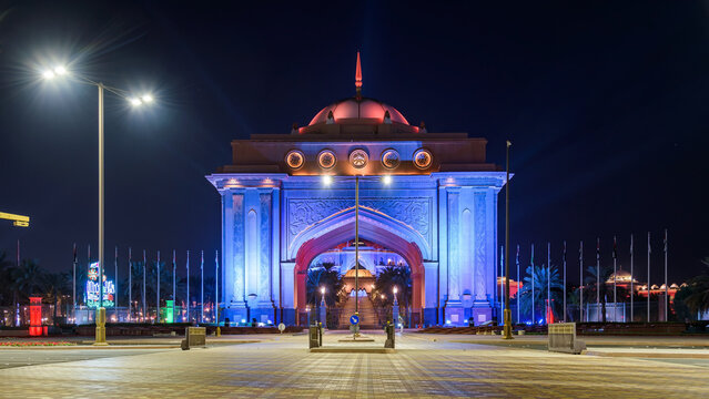 The grand illuminated main gate entrance to Emirates Palace in Abu Dhabi at night