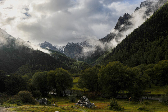 Green Valley Meadow with Stone Mani Pile and Mountains
