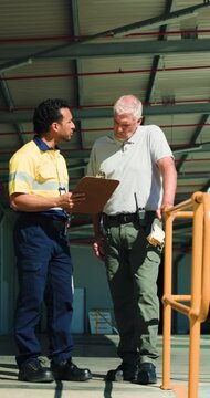 Clipboard, logistics and meeting with men outdoor together for delivery or shipping management. Conversation, paperwork and teamwork with supply chain people at distribution plant for planning