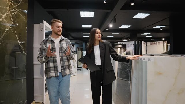 Designer assisting client selecting granite tiles in showroom