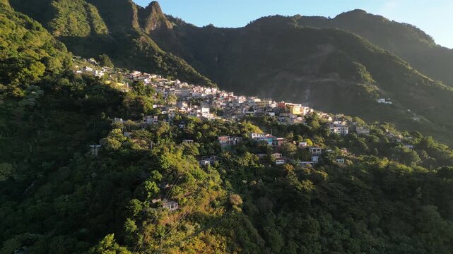 historic mayan village in lake atitlan guatemala (santa cruz la laguna) small homes maya residents side of mountain volcanic caldera volcano travel tourism poverty traditional native aerial