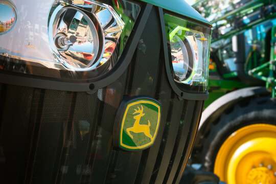 Perforated front grille with John Deere logo, integrated halogen LED headlights, and robust agricultural tractor structure.