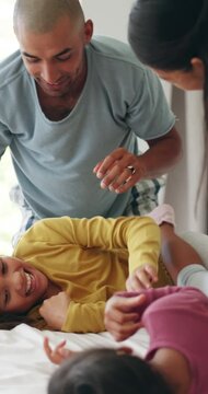 Parents, children and laugh on bed for tickle, bonding and playful relationship in morning. Family home, siblings and people in bedroom with game, weekend and excited together for childhood fun