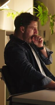 Businessman, burnout and yawning in office at night, online and reporter with computer or low energy. Newsroom, overtime and person with fatigue for deadline, creative and working late with tech