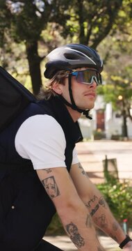 Delivery, bike or man in park with travel, bag or package distribution in eco friendly trip. Service, cycling helmet or person with parcel, bicycle riding or courier in sustainable transportation.