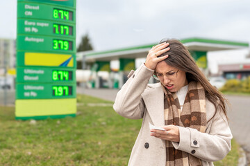 High gas prices woman reading receipt at station © Maksym