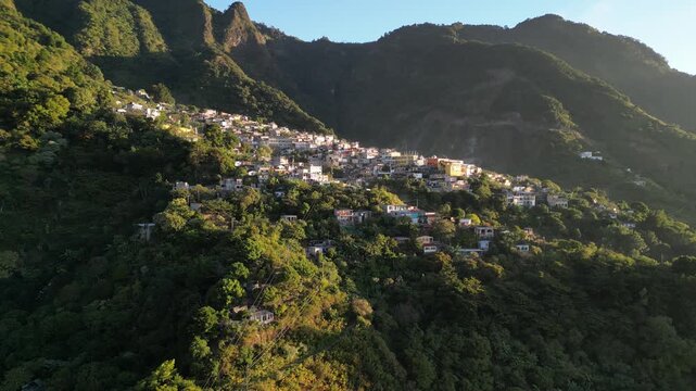 historic mayan village in lake atitlan guatemala (santa cruz la laguna) small homes maya residents side of mountain volcanic caldera volcano travel tourism poverty traditional native aerial