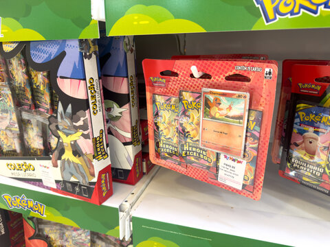 BELO HORIZONTE, MG, BRAZIL, APRIL 11, 2026 A single blister pack featuring a Charizard card and booster packs is prominently displayed on a store shelf amidst other Pok&eacute;mon merchandise.